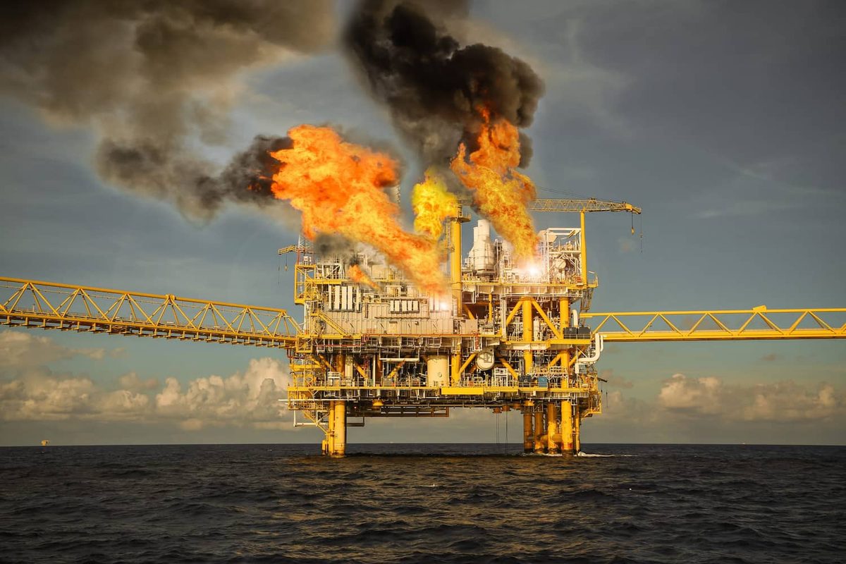 Brennende Offshore-Ölplattform mit Flammen und Rauchsäule auf hoher See, Beispiel für Explosionsgefahr in der Öl- und Gasindustrie