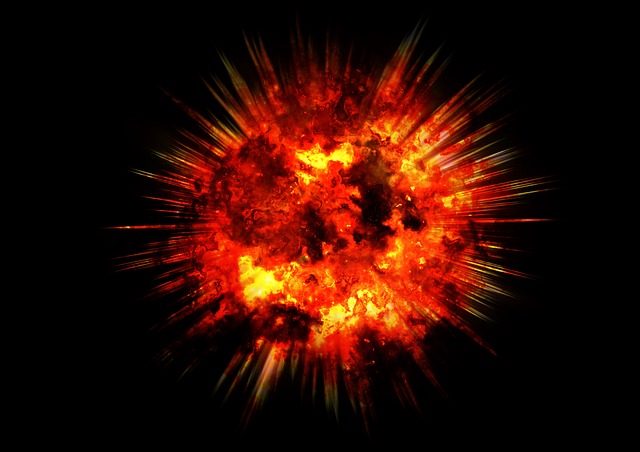 Roter Explosionsfeuerball mit Funkenflug auf schwarzem Hintergrund, Symbolbild für eine Staubexplosion in industrieller Umgebung